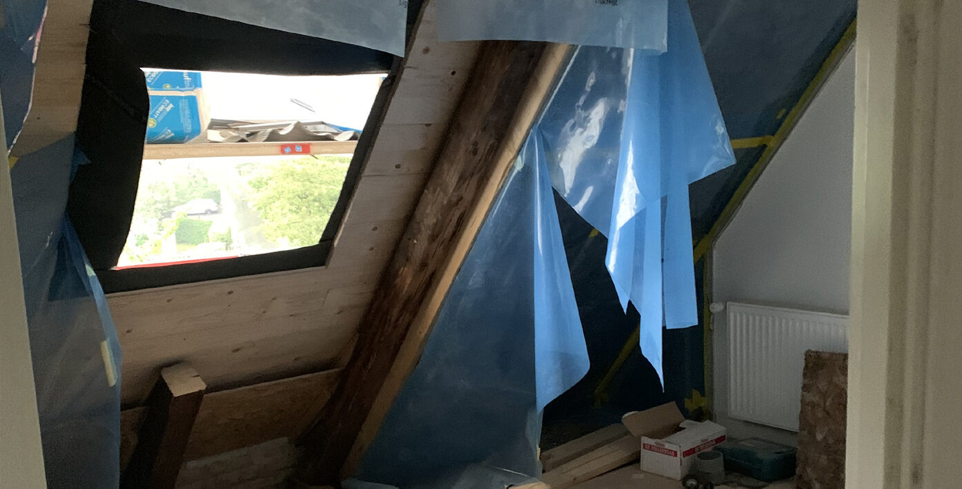 Blå dampspærrefolie tilpasset omkring spær og ovenlysvindue i et loftsrum under renovering