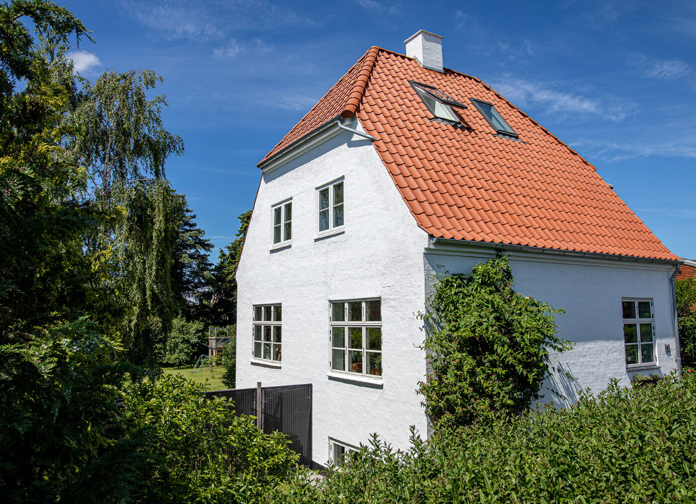 Villaens gavl og nye tegltag set tæt på fra haven