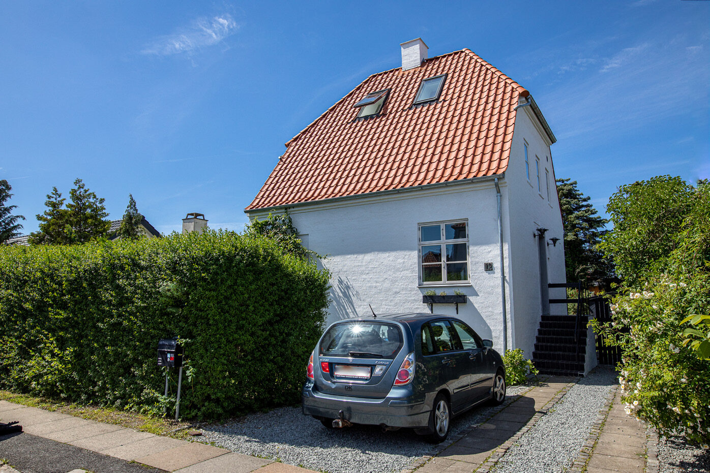 Villaen set fra indkørslen med nyt tegltag, nye tagrender og hvid skorsten